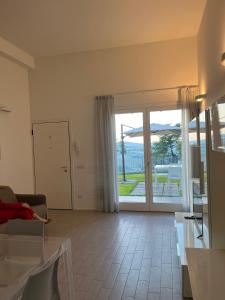 ein Wohnzimmer mit einem Sofa und einem großen Fenster in der Unterkunft Tramonto - Le Grotte Rooms & Apartments in Camerano