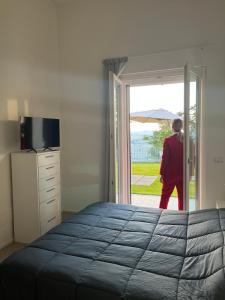 Um homem num quarto a olhar pela porta em Tramonto - Le Grotte Rooms & Apartments em Camerano