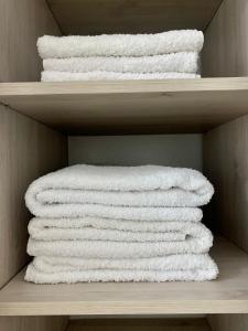 un grupo de toallas blancas en un estante en AIKA Monoambientes en Salta