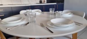 Apartament 51 في تورون: طاولة بيضاء عليها صحون بيضاء و فضيات