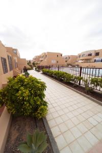 Una pasarela en un patio con edificios y plantas. en SUN BAY, en Caleta de Fuste