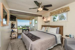 a bedroom with a bed and a ceiling fan at Juan de Fuca Cottages in Sequim