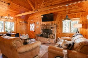 ein Wohnzimmer mit Sofas und einem Kamin in einer Hütte in der Unterkunft Cozy Cabin about 3 Mi to Big Trees State Park! in Arnold