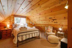 ein Schlafzimmer mit einem Bett in einem Blockhaus in der Unterkunft Cozy Cabin about 3 Mi to Big Trees State Park! in Arnold
