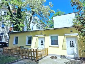 una casa amarilla con una valla de madera delante de ella en HappySide TinyHouse - Terasse - Hunde bis 5 KG, en Leipzig