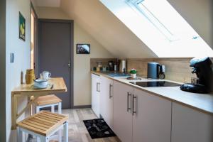 eine Küche mit weißen Schränken und einem Dachfenster in der Unterkunft la maison d'Elise in Dollon