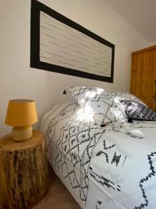 - une chambre avec un lit et une table avec une lampe dans l'établissement Cases des oliviers, à Cases-de-Pène