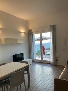 ein Wohnzimmer mit einem Tisch und Blick auf einen Innenhof in der Unterkunft Alba - Le Grotte Rooms & Apartments in Camerano