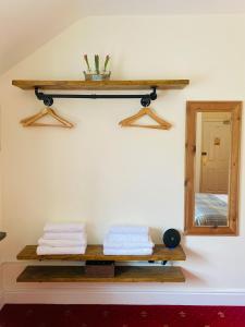 a bathroom with a mirror and towels on a shelf at The Gordon Arms Restaurant with Rooms in Yarrow
