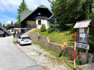 a car parked on the side of a road next to a house at Chalet Anita Rogla in Zreče