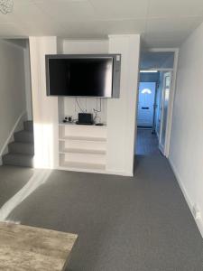 a living room with a flat screen tv on a wall at Beautiful-2 bedroom Apartment, 1 bathroom, sleeps 6, in greater london (South Croydon). Provides accommodation with WiFi, 3 minutes Walk from Purley Oak Station and 10mins drive to East Croydon Station in Purley