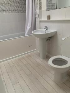 a bathroom with a toilet and a sink and a tub at Beautiful-2 bedroom Apartment, 1 bathroom, sleeps 6, in greater london (South Croydon). Provides accommodation with WiFi, 3 minutes Walk from Purley Oak Station and 10mins drive to East Croydon Station in Purley