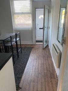 a dining room with a table and a table and a door at Beautiful-2 bedroom Apartment, 1 bathroom, sleeps 6, in greater london (South Croydon). Provides accommodation with WiFi, 3 minutes Walk from Purley Oak Station and 10mins drive to East Croydon Station in Purley