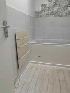 een witte badkamer met een bad en een houten vloer bij Beautiful-2 bedroom Apartment, 1 bathroom, sleeps 6, in greater london (South Croydon). Provides accommodation with WiFi, 3 minutes Walk from Purley Oak Station and 10mins drive to East Croydon Station in Purley