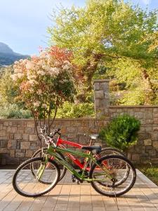 un vélo vert et rouge garé à côté d'un mur de pierre dans l'établissement Seaside retreat house, à Paralía Sergoúlas