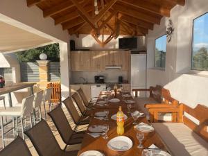 een eetkamer met een lange tafel en een keuken bij Nefeli Villa in Panormos Rethymno