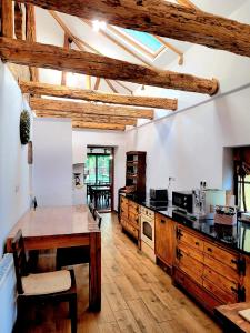 a kitchen with wooden cabinets and a wooden table at Joyard - Pensiune & Parc in Porumbacu de Sus