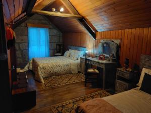 a bedroom with two beds in a room with wooden walls at Casas Zé Pinto in Hospital