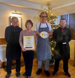 un gruppo di persone che posano per una foto con un premio di The Gordon Arms Restaurant with Rooms a Yarrow