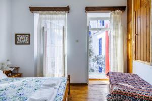 - une chambre avec un lit et une grande fenêtre dans l'établissement House Vasaki, à Skopelos