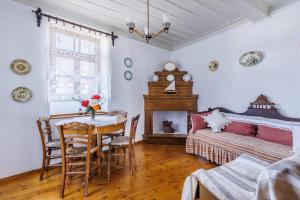 jadalnia ze stołem i łóżkiem oraz sypialnia w obiekcie House Vasaki w mieście Skopelos