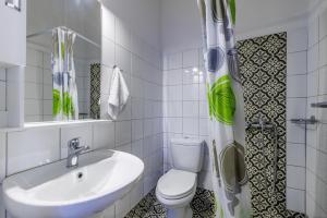 uma casa de banho branca com um lavatório e um WC em House Vasaki em Skopelos