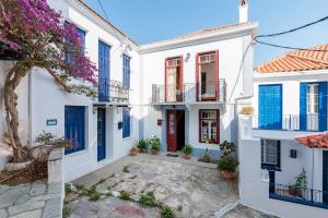 una fila de casas blancas con persianas azules en House Vasaki, en Skopelos Town