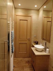 a bathroom with a sink and a toilet and a door at Seaside retreat house in Paralía Sergoúlas