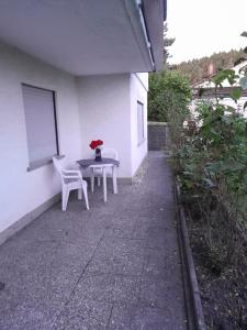 a table and chairs sitting on the side of a house at Ferienwohnung Michelbach an der Bilz mit Parkplatz und Küche für 1 bis 5 Personen in Michelbach an der Bilz