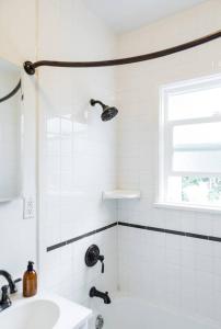 La salle de bains blanche est pourvue d'un lavabo et d'une fenêtre. dans l'établissement Cozy Apartment at the Central of Eagle Rock, à Los Angeles