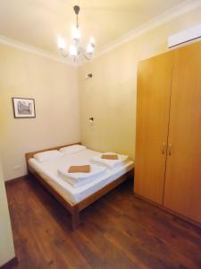 a bedroom with a bed and a wooden cabinet at Belokorichi in Kyiv