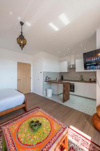 a living room with a bed and a kitchen at Le Petit Riad in Vilvoorde