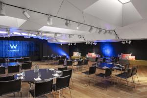 a stage with tables and chairs in a room with blue lights at W Amsterdam in Amsterdam +279 photos