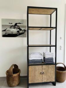 a shelf with towels and a picture of a car at Penthouse im Herzen von Herborn in Herborn