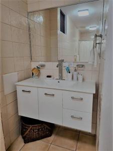 uma casa de banho branca com um lavatório e um espelho em Rincon Retreat,- Close to beach/ Ocean Front em Corcega