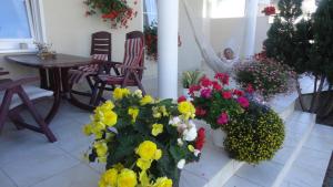 a woman is sitting in a room with flowers at Pensjonat Amor in Mielno