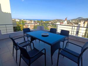 una mesa azul y sillas en el balcón en Petros House Artemis - Near the Airport, en Artemida