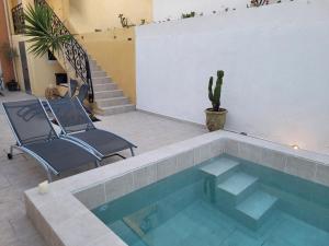 basen z 2 krzesłami i kaktusem w obiekcie L Arancio - Centre village - Piscine - 4 pers w mieście Bessan