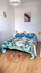 uma cama com um edredão colorido num quarto em Appartement Le Gambetta em Troyes