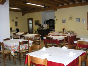 a dining room with tables and chairs with white tablecloths at Agriturismo Ca' Licante in Bardolino