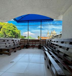 a group of benches with a large blue umbrella at Hotel Costa Caribe in Barranquilla