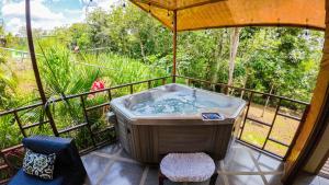 un bain à remous sur un balcon avec vue dans l'établissement Bungalows Las Iguanas Arenal Volcano, à Fortuna