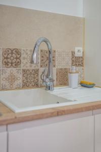 um lavatório de cozinha com uma torneira cromada e azulejos em Casa Sweet In em Vilvoorde