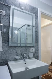 a bathroom with a white sink and a mirror at Fishta apartments Q5 35 in Velipojë