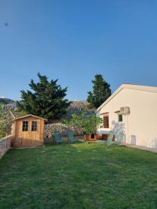 a yard with chairs and a white building at Haus Fernweh in Rtina