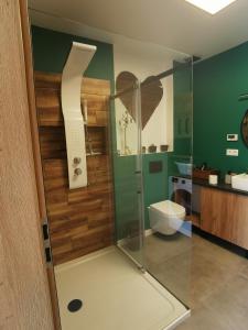 La salle de bains est pourvue d'une douche avec une porte en verre. dans l'établissement Zielony Zakątek Ciężkowice, à Ciężkowice