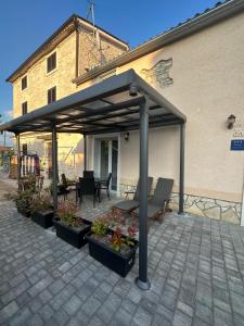 a pergola with a table and chairs on a patio at Farfalle di Valle in Bale