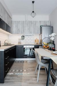 a kitchen with black cabinets and a table with chairs at Casa Karma in Volos
