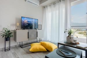 a living room with a tv and a yellow pillow at Casa Karma in Volos
