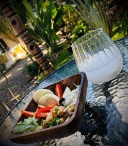 a bowl of food on a table with a glass of milk at Nautilus Hostel & Hammocks in Panglao Island